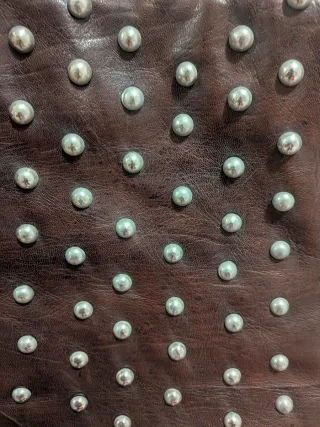 Bolso de piel marrón con tachuelas