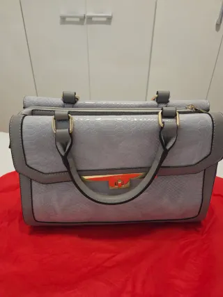 Bolso gris y dorado con textura piel serpiente.
