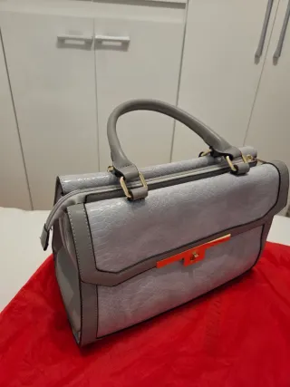 Bolso gris y dorado con textura piel serpiente.