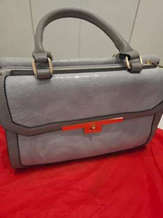 Bolso gris y dorado con textura piel serpiente.