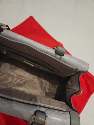 Bolso gris y dorado con textura piel serpiente.