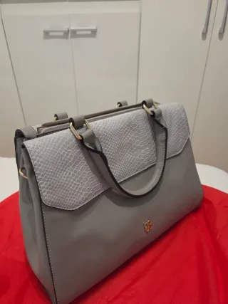 Bolso gris y dorado con textura piel serpiente.