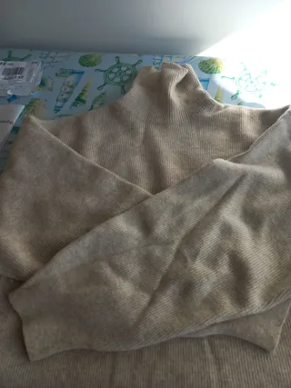 Jersey cuello alto beige, con un 89 % de lana