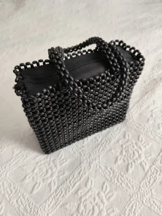 Bolso Wallis negro semillas entrelazadas.