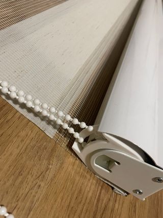 Store Cortina de tela beige y blanca