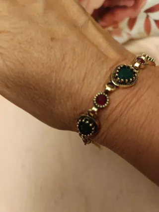 Pulsera dorada con piedras verdes y rojas