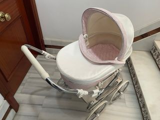 Carro de muñecas blanco y rosa.