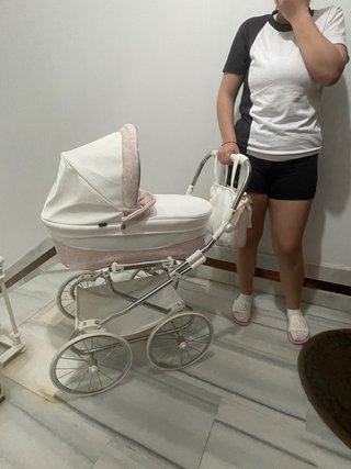 Carro de muñecas blanco y rosa.