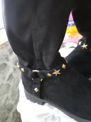 Botas pretas até o joelho com detalhes dourados