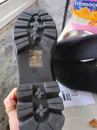 Botas pretas até o joelho com detalhes dourados