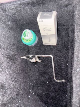 saxofón nuevo con atril caja de cañas y vaselina.