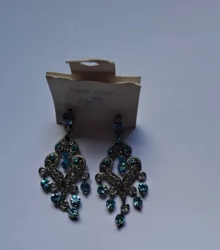 Pendientes largos plateados con piedras azules.