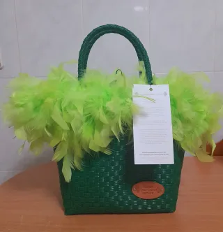 Bolso de mano verde con plumas