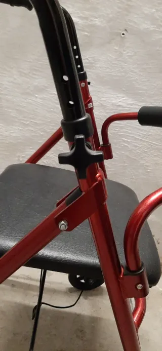 Andador con asiento rojo.