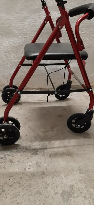 Andador con asiento rojo.