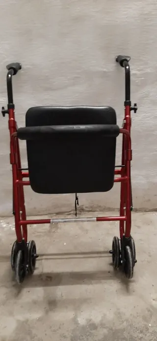 Andador con asiento rojo.