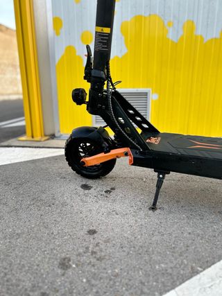 Patinete eléctrico negro con detalles naranjas