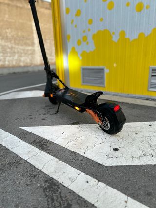 Patinete eléctrico negro con detalles naranjas