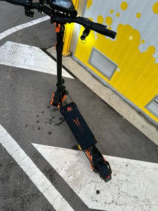 Patinete eléctrico negro con detalles naranjas