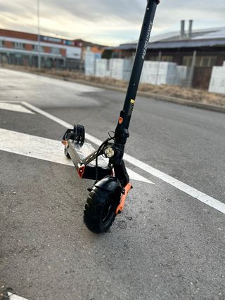 Patinete eléctrico negro con detalles naranjas