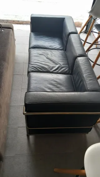 Sofá de piel negro con estructura metálica