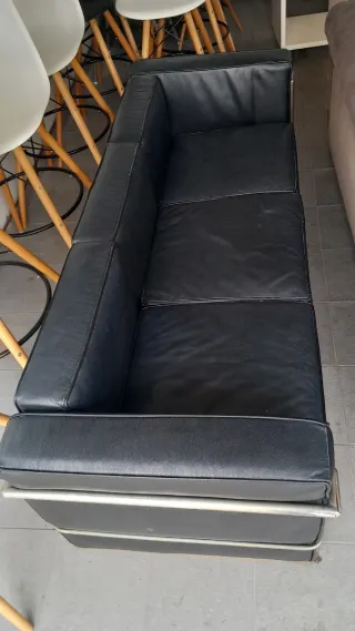 Sofá de piel negro con estructura metálica