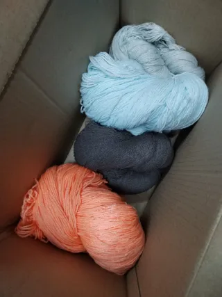 Caja de lana con madejas con manchas