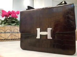 Bolso de cuero marrón con H plateada