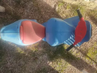 Moto correpasillos azul y roja desgastada por uso