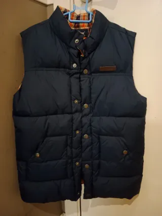 Chaleco acolchado azul con forro a cuadros.