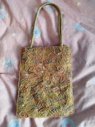 Bolso de mano dorado con asa