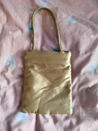 Bolso de mano dorado con asa
