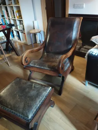 Butaca y reposapiés de cuero y madera.