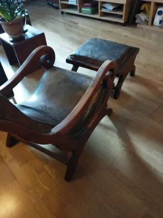 Butaca y reposapiés de cuero y madera.
