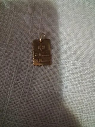 Placa de oro con cruz y letras