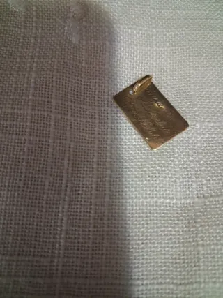 Placa de oro con cruz y letras