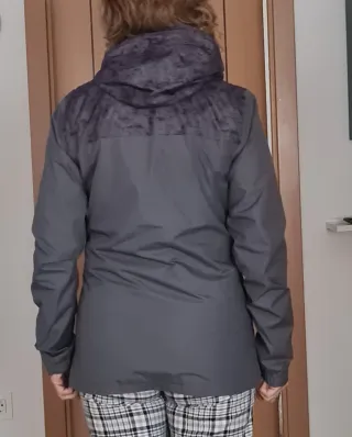 Chubasquero cortavientos gris y negro.