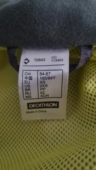 Chubasquero cortavientos gris y negro.