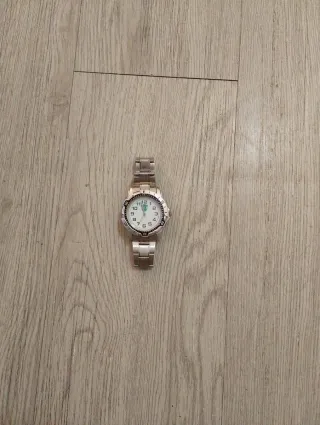 Reloj plateado con detalles verdes