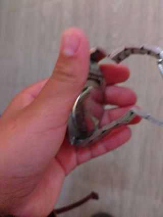 Reloj plateado con detalles verdes