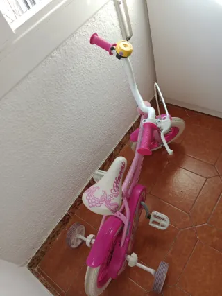 Bicicleta infantil rosa con ruedas de apoyo