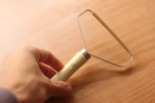 Quitapelusas manual madera y metal.