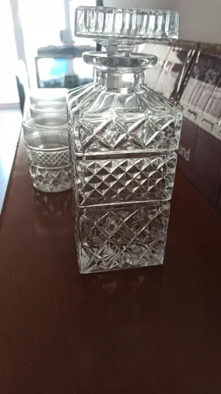 Botella de cristal con vasos y posavasos