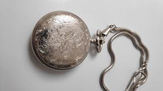 Reloj de bolsillo plateado con cadena