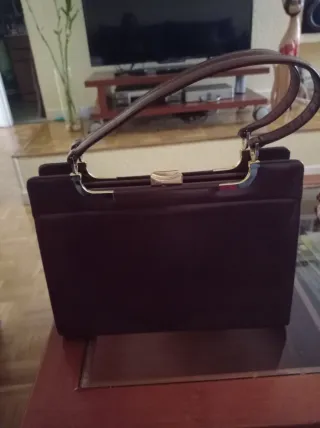 Bolso piel marrón dos asas y boquilla dorada.