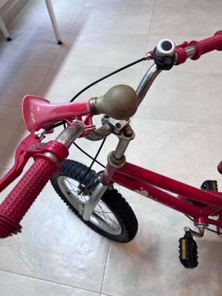 Bicicleta infantil roja con ruedines