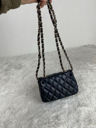 Mala Chanel preta com detalhes dourados