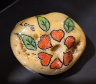 Pietre dipinte a mano con fiori e scritte