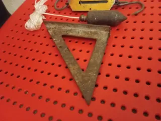 Herramientas antiguas: escuadra, plomada, báscula