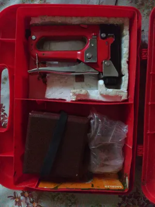 Grapadora manual roja con maletín